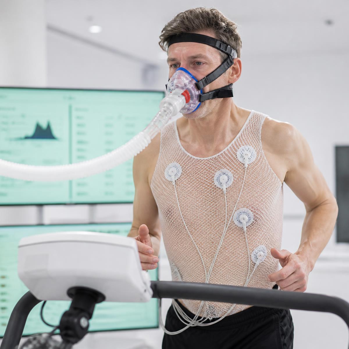 Adult performing a VO2max treadmill test with a gas-exchange mask and ECG sensors